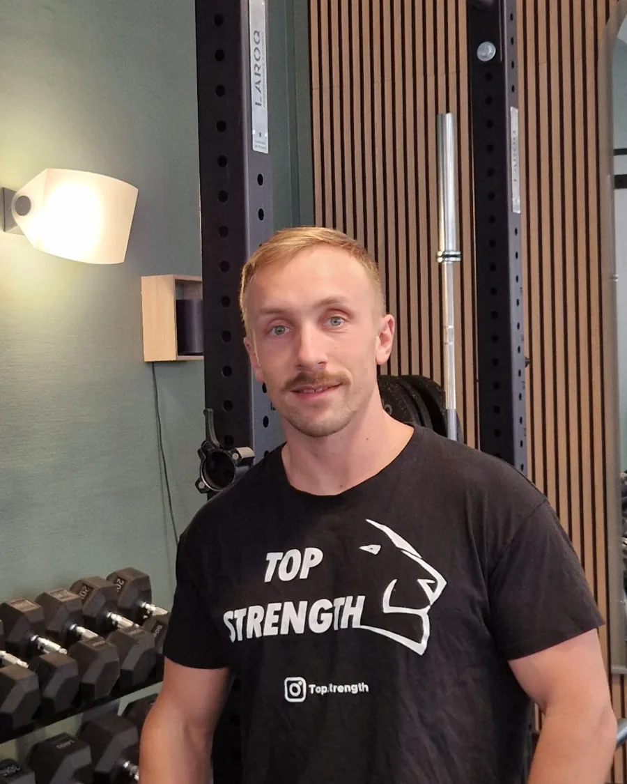 Alexandre, fondateur et coach du studio Top Strength à Lyon 6, devant le rack et les haltères
