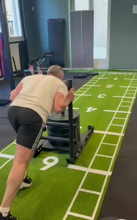 Poussée de sled chargé sur la piste en gazon synthétique numérotée, préparation Hyrox au studio Top Strength à Lyon 6