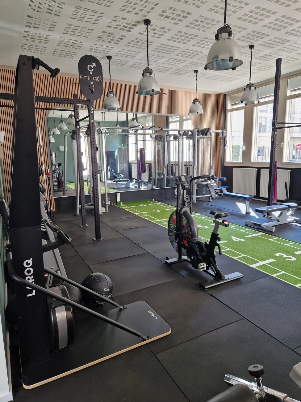 Espace cardio du studio Top Strength à Lyon 6 : vélo à air, rameur, skierg, poulies et piste de sled
